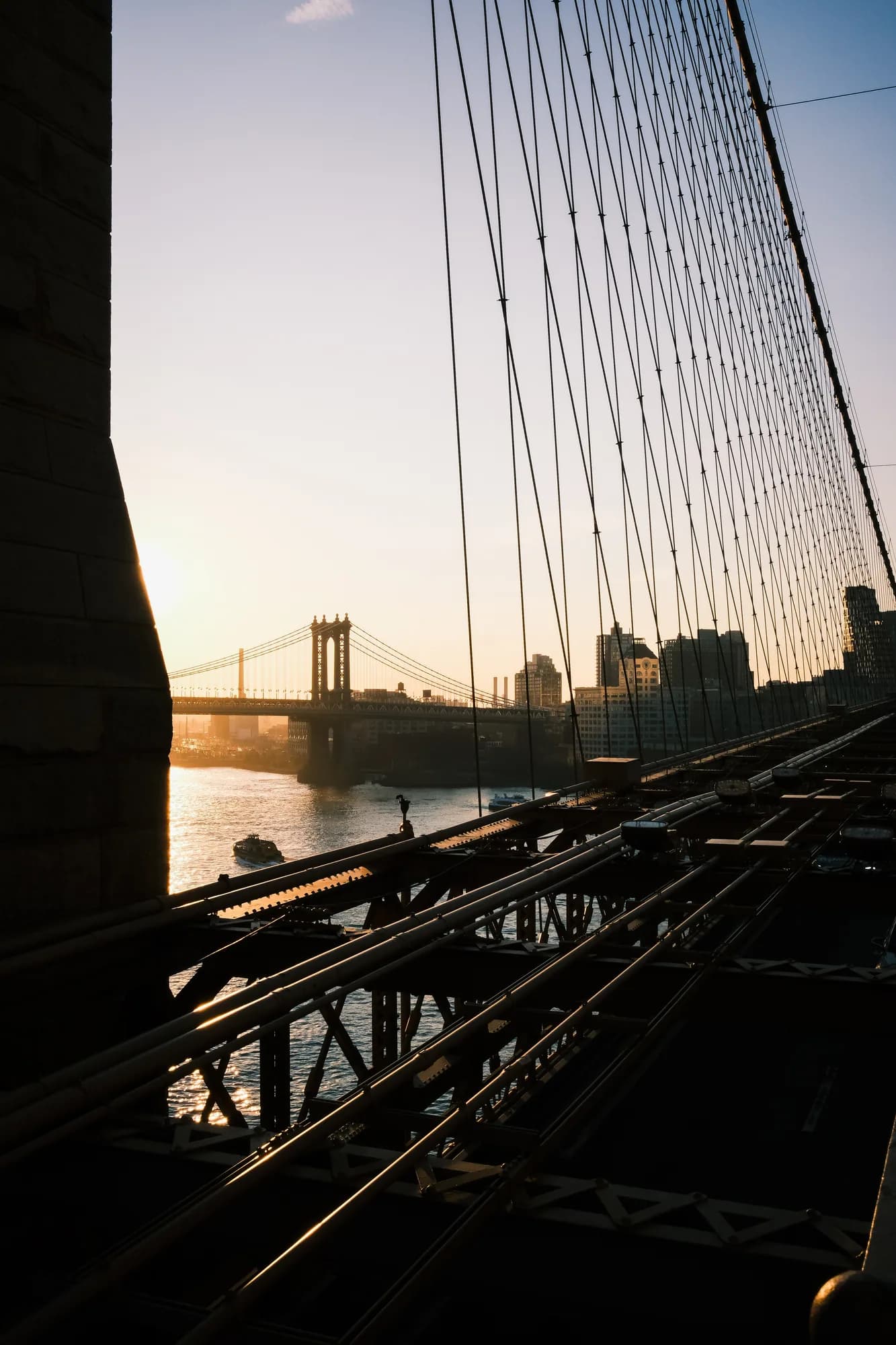 Sunrise through the cables of the Brooklyn Bridge with the Manhattan Bridge in the distance