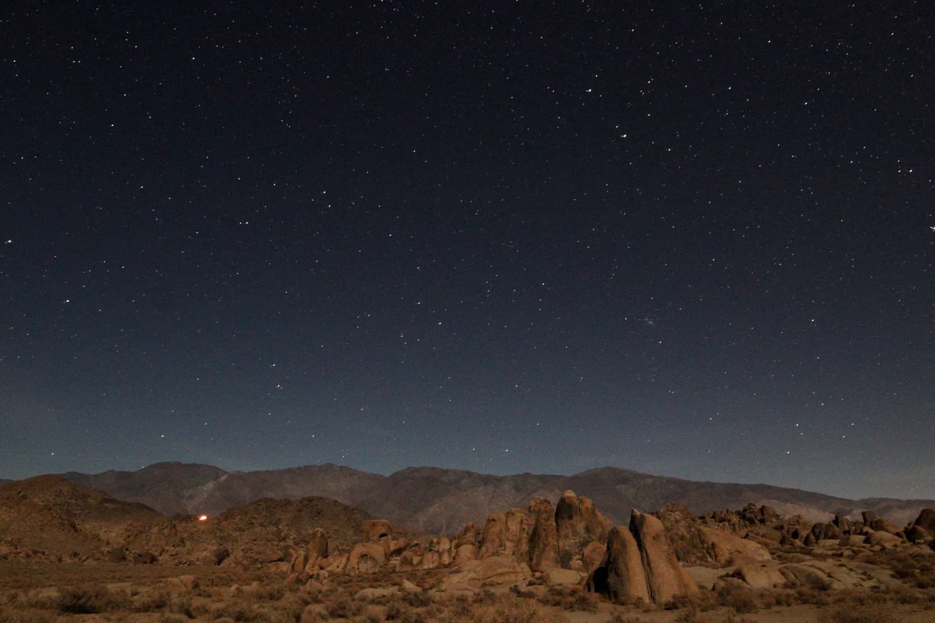 Stars over desert rock formations at night