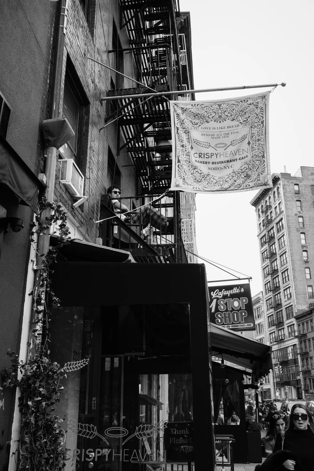 Black and white photo of fire escapes and a hanging banner on a New York City street